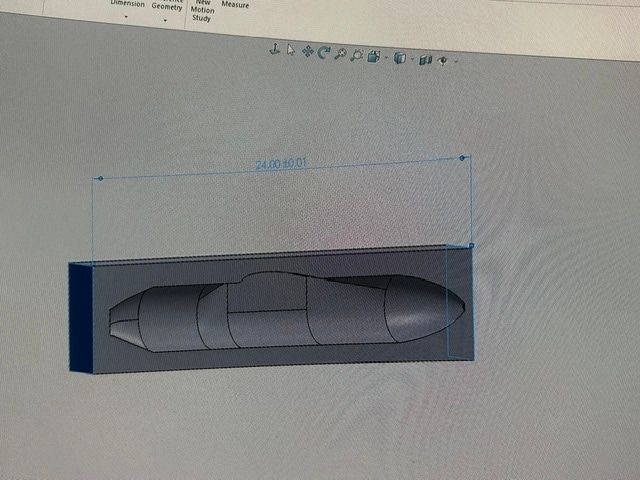 SolidWorks screen showing a rectangular block with the fuselage profile set into it, dimensioned along its length.